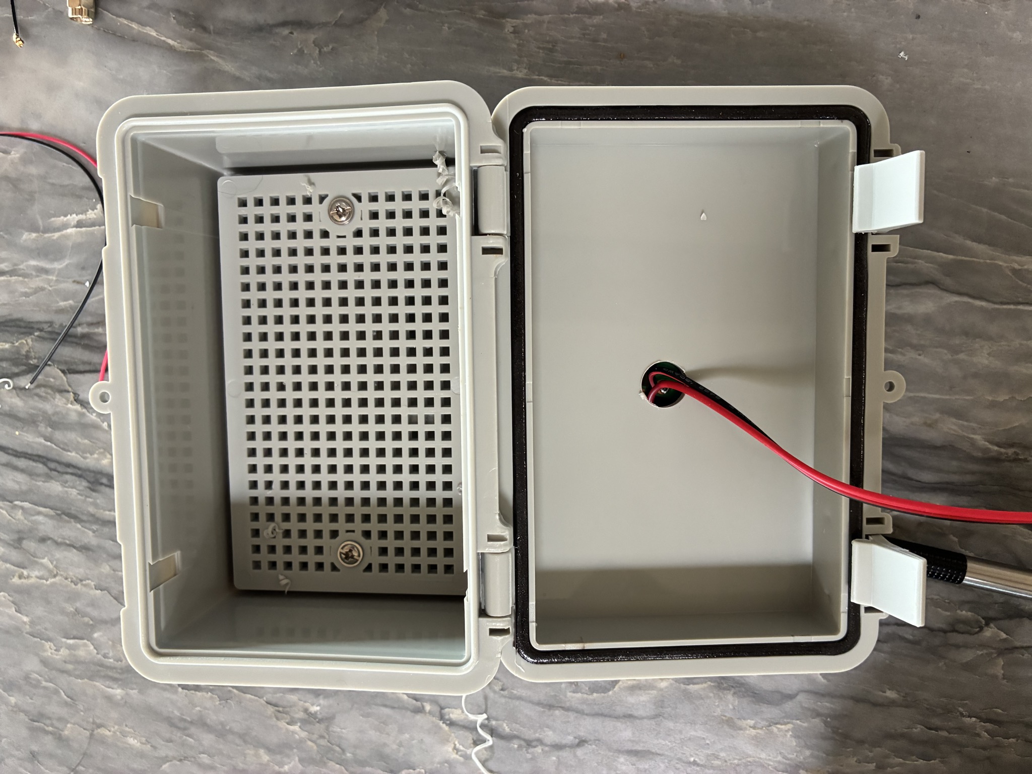 Enclosure lid with 1/2 inch hole drilled and power leads routed through