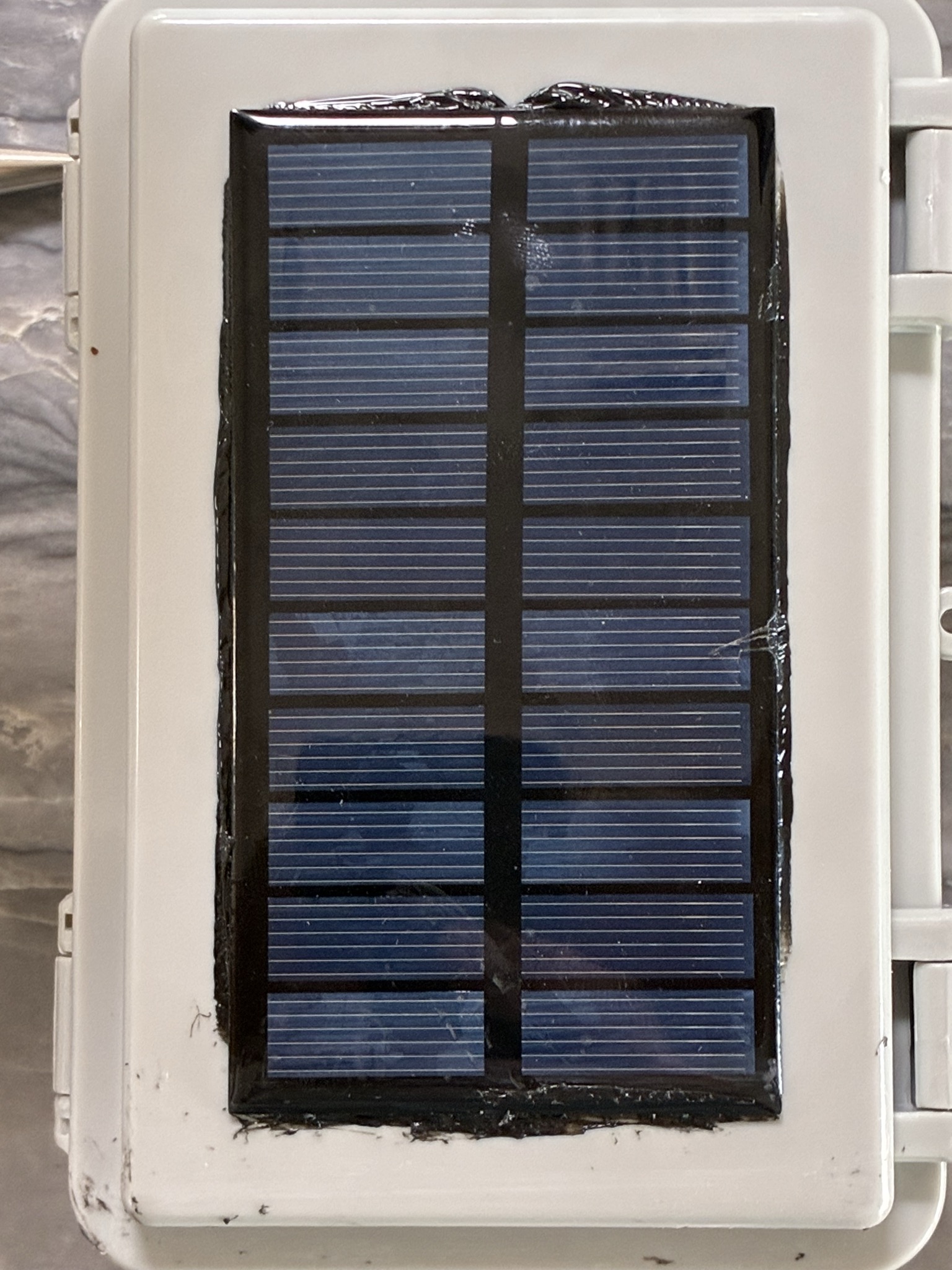 Solar panel with sealant applied around the perimeter and leads routed